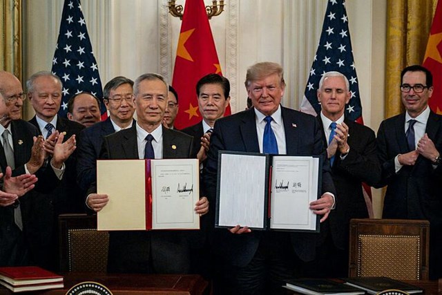 Tổng thống Mỹ Donald Trump v&agrave; Ph&oacute; thủ tướng Trung Quốc Lưu Hạc trong buổi k&yacute; kết h&ocirc;m qua. (Ảnh: NYT).