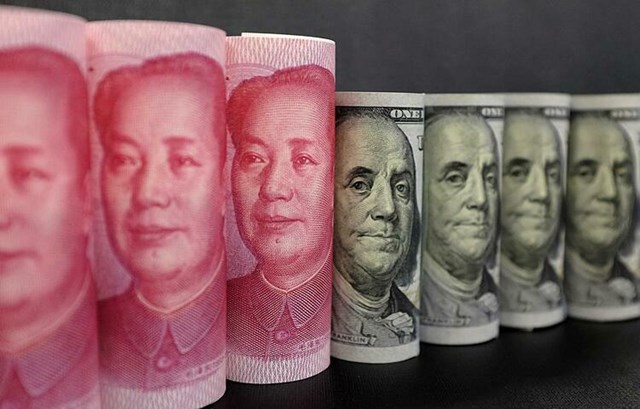Tiền nh&acirc;n d&acirc;n tệ của Trung Quốc v&agrave; đ&ocirc;la Mỹ. Ảnh:&nbsp;Reuters