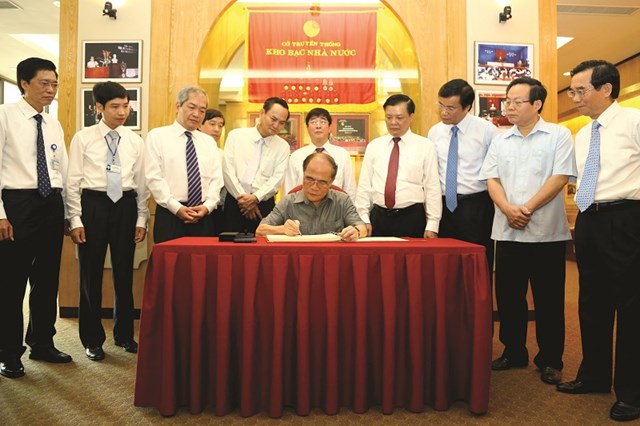 Chủ tịch Quốc hội Nguyễn Sinh H&ugrave;ng ghi số lưu niệm tại ph&ograve;ng truyền thống KBNN (năm 2013)