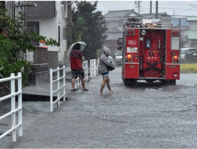 Cư d&acirc;n phường Suruga, Shizuoka đang sơ t&aacute;n khỏi khu phố bị ngập lụt do mưa lớn