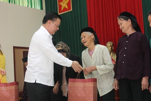 Bộ trưởng Đinh Tiến Dũng trao qu&agrave; cho đại diện c&aacute;c gia đ&igrave;nh ch&iacute;nh s&aacute;ch.