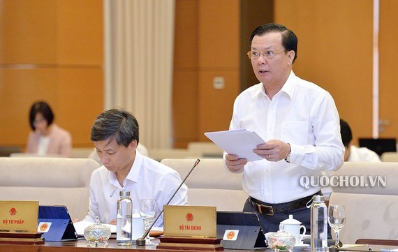 Bộ trưởng Đinh Tiến Dũng đọc Tờ trình của Chính phủ và cho ý kiến về dự thảo Nghị định, sáng 17/9.
