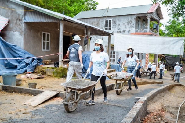 Các tình nguyện viên JTI và đối tác chung tay vận chuyển nguyên liệu để xây dựng ngôi nhà tại Hòa Bình.