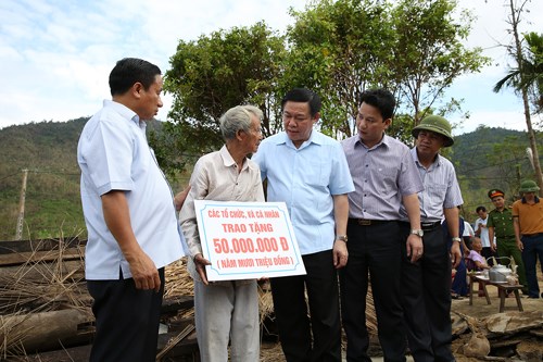 Phó Thủ tướng tặng quà hỗ trợ gia đình ông Trương Huấn (thôn Bắc Tiến, xã Kỳ Thượng, huyện Kỳ Anh) tu sửa nhà cửa do bão số 10. Ảnh: VGP/Thành Chung