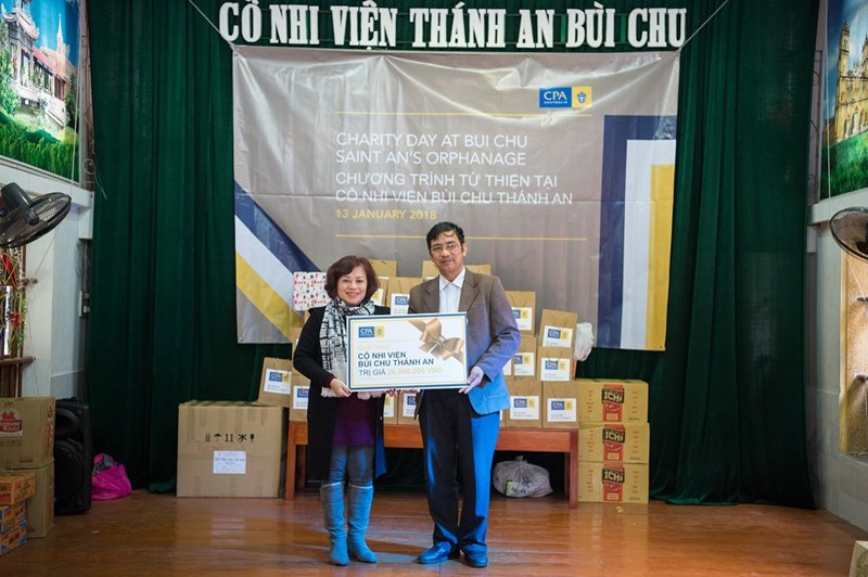 Bà Trần Thiên Hương, Trưởng Đại diện CPA Australia tại Việt Nam trao biểu trưng quà tặng trị giá 20 triệu đồng cho Thầy Giuse Vũ Minh Tiến, Đại diện Cô nhi viện.