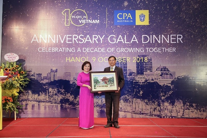 bà Trần Thiên Hương, Trưởng Đại diện CPA Australia đón nhận quà lưu niệm từ Chủ tịch VAA, Tiến sỹ Đặng Văn Thanh vì những hỗ trợ và hợp tác quý báu giữa 2 tổ chức