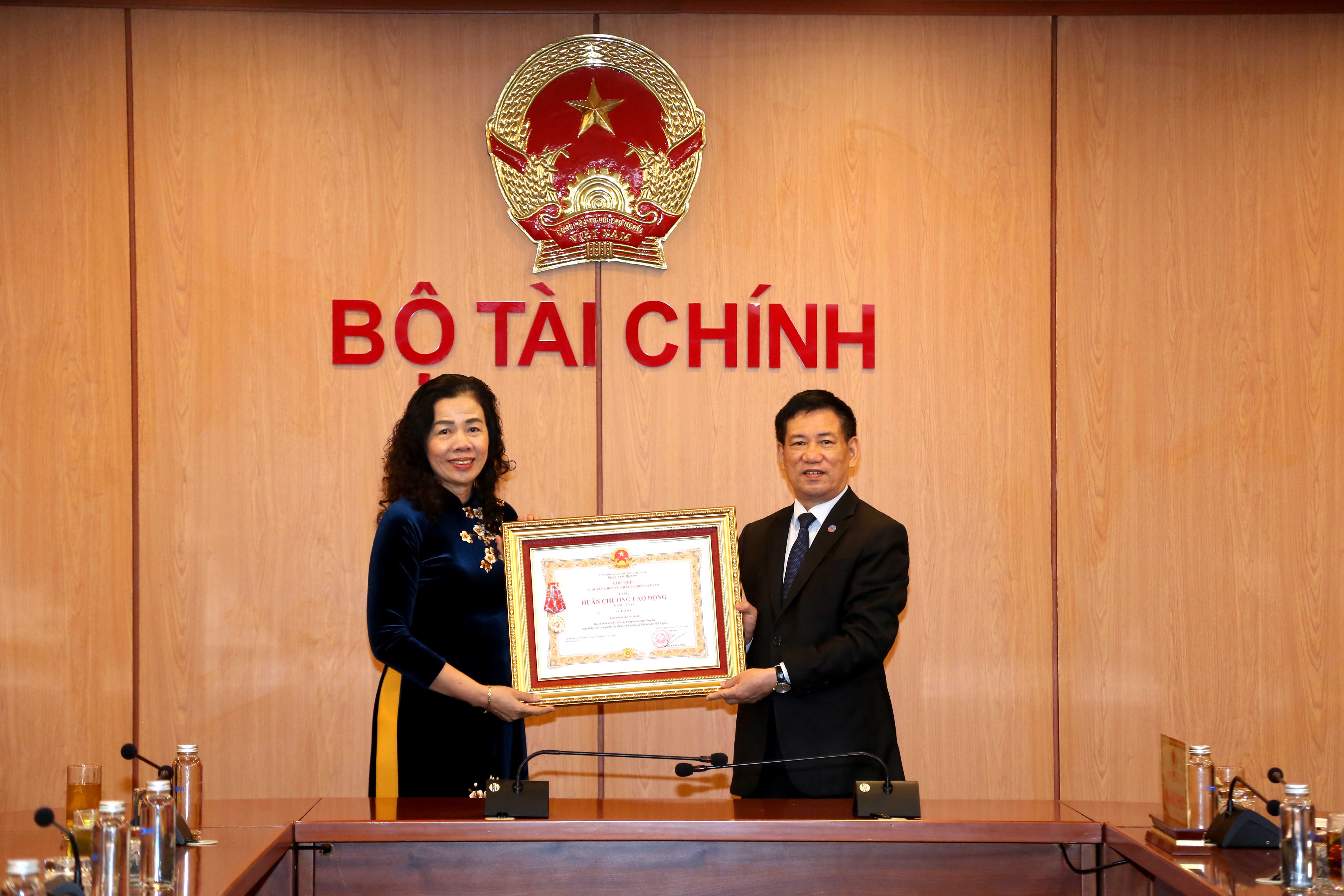 Thừa ủy quyền của Chủ tịch nước, Bộ trưởng Hồ Đức Phớc trao Hu&acirc;n chương Lao động hạng Nhất cho Thứ trưởng Vũ Thị Mai.