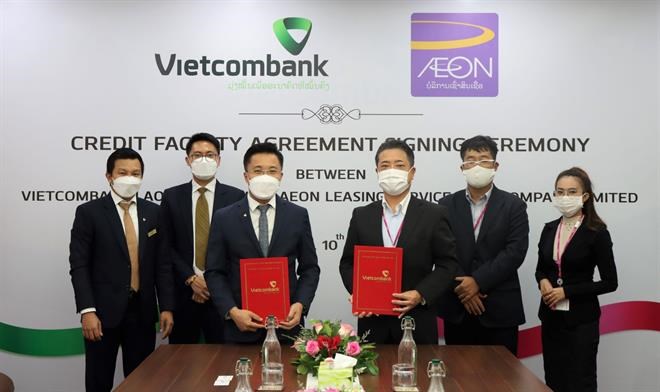 Ông Nguyễn Thành Đô–Thành viên HĐQT, Tổng giám đốc Vietombank Lào (hàng đầu bên trái) cùng ông Kunio Kawamura–Giám đốc điều hành AEON Lào (hàng đầu bên phải) thực hiện nghi thức ký kết